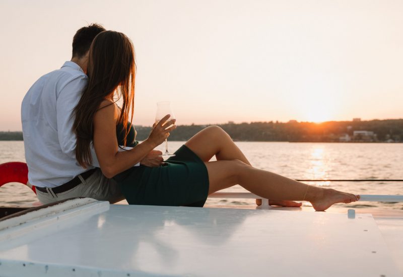 A,Loving,Couple,On,A,Yacht,Looks,At,The,Sunset.